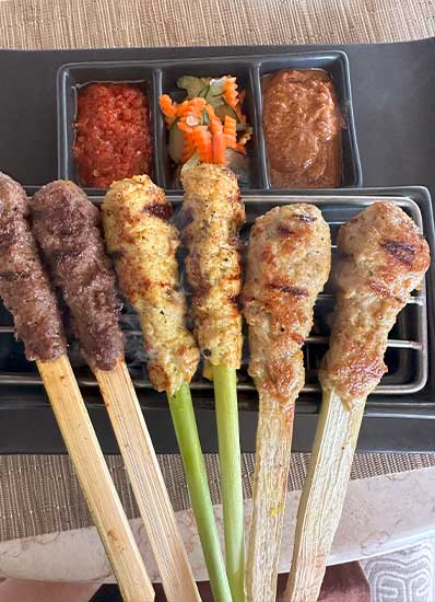 Delicious Satay Lilit which is Balinese Mixed Satay of Chicken, Beef and Fish, served with peanut sauce, samba and picked vegetables