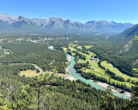 One of the stunning views from the top of Tunnel Mountain showcases the Bow River, Banff Springs Golf Course, and the majestic surrounding mountains.